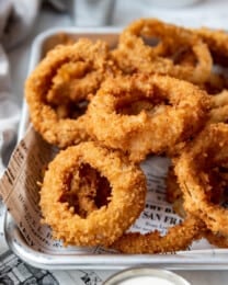 Crispy fried onions rings on a baking sheet.