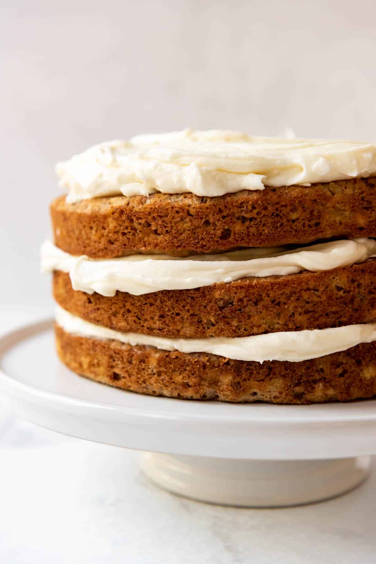 Three layers of hummingbird cake with cream cheese frosting spread between them.