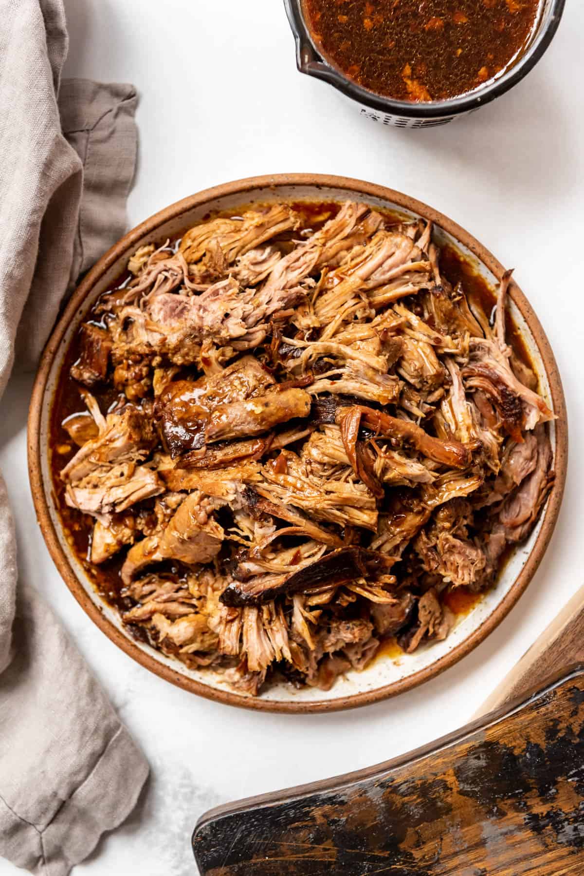 A plate full of Instant Pot pork roast that has been shredded and drizzled with glaze.