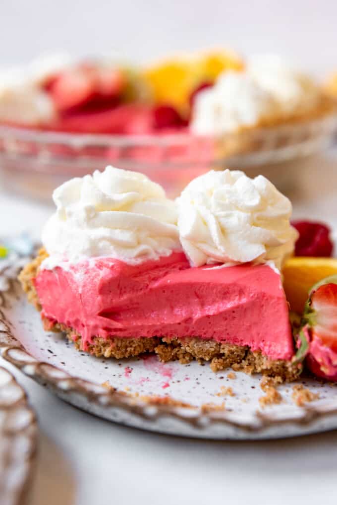 A slice of Kool-Aid pie on a plate with a bite taken out of it.
