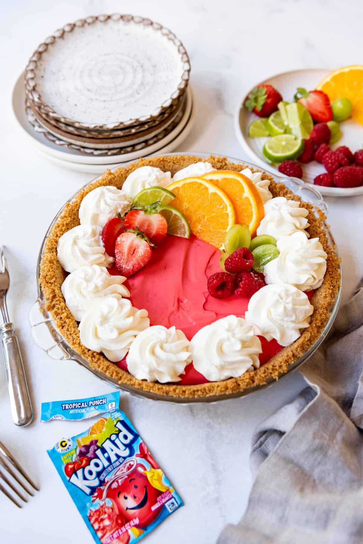 A tropical punch Kool-Aid pie decorated with whipped cream and fresh fruit.