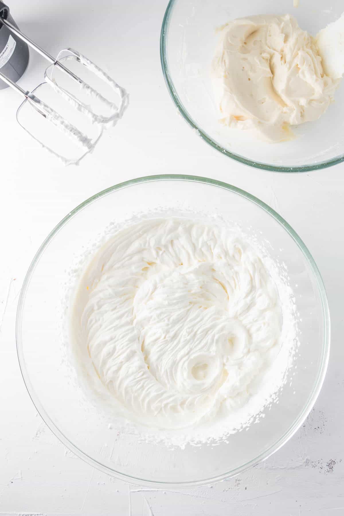 Beating heavy cream in a glass mixing bowl.