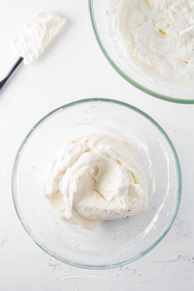 Beating cream cheese until smooth in a glass mixing bowl.