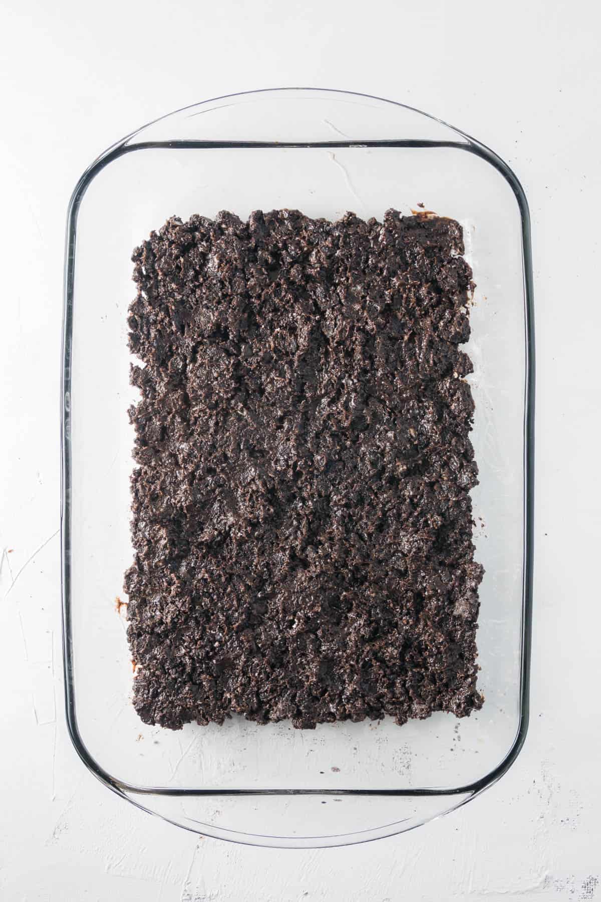 Oreo crust pressed into a large rectangular baking dish.