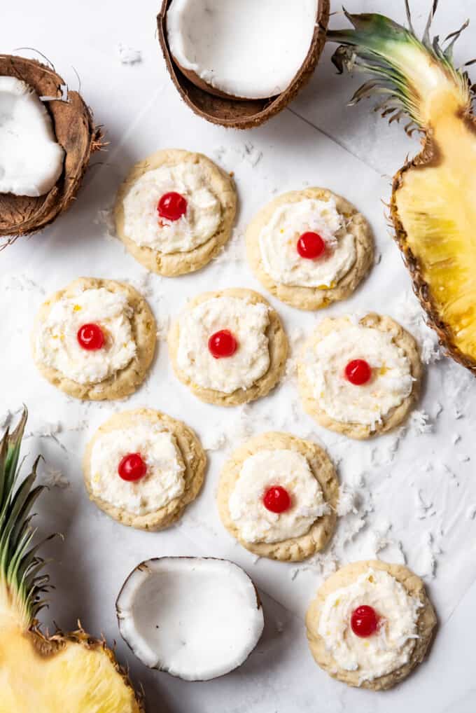 An overhead image of pina colada cookies surrounded by coconut halves and pineapple.