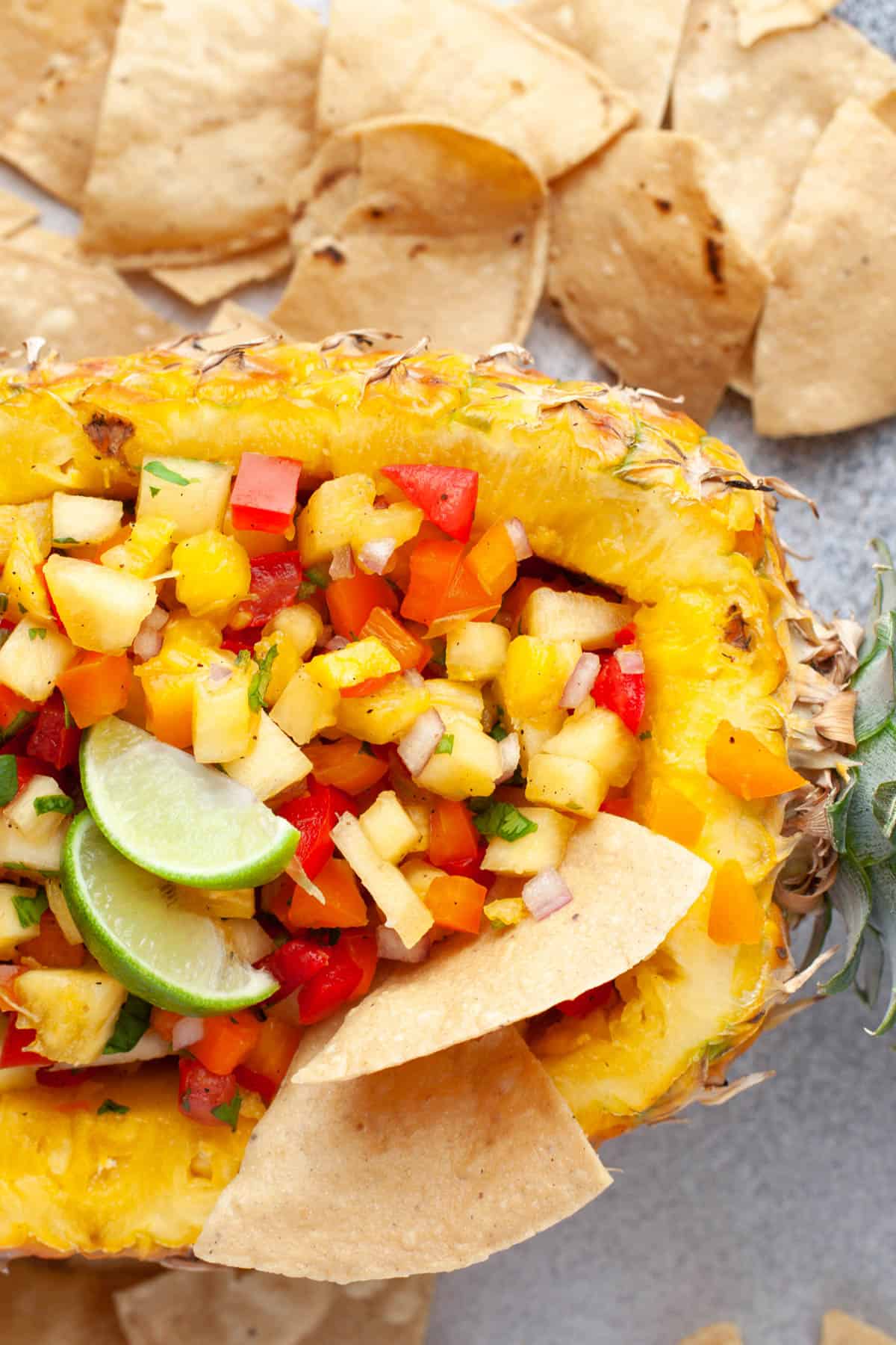 Fresh pineapple salsa with tortilla chips and lime wedges.