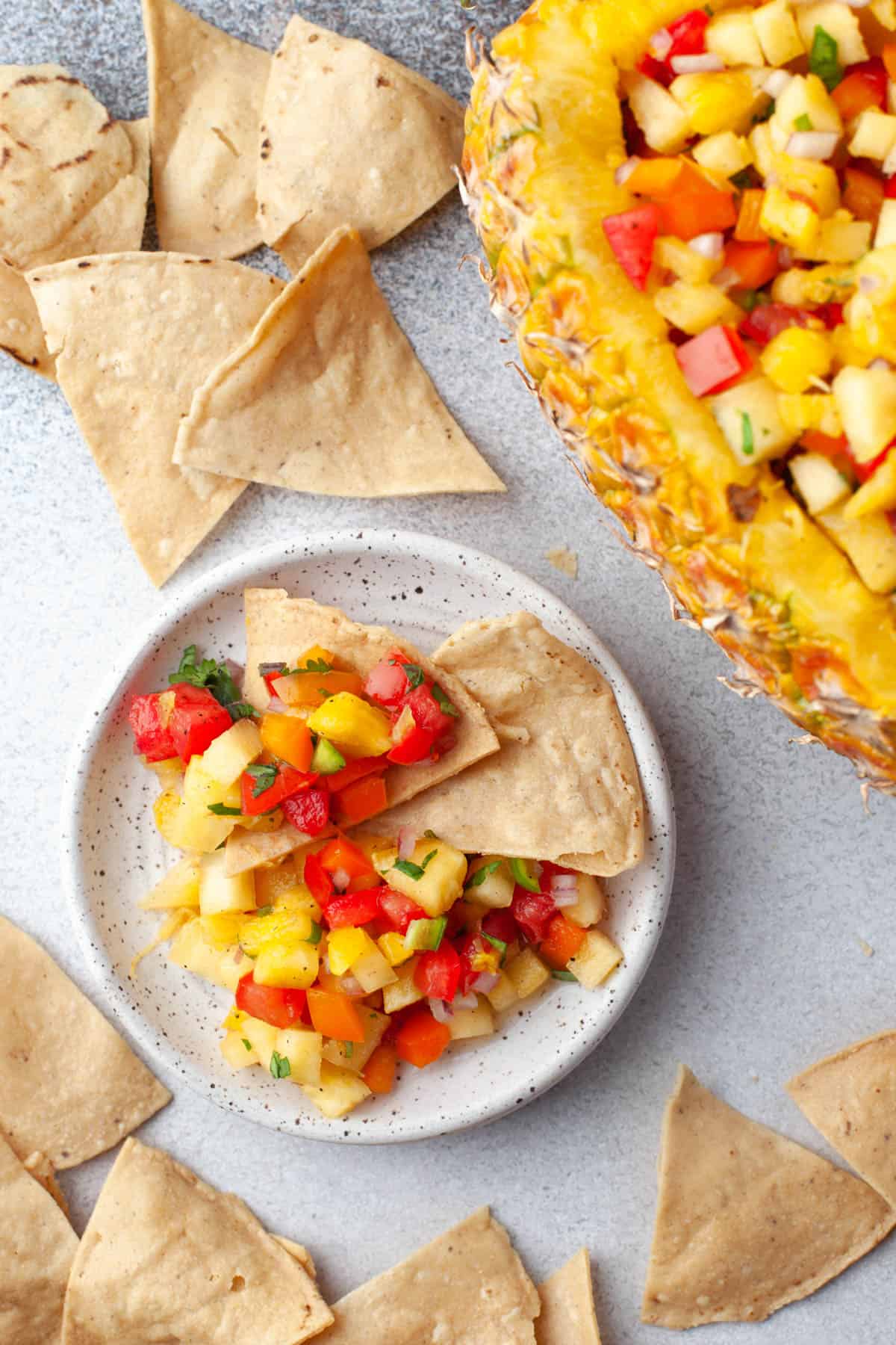 An overhead image of a small plate with pineapple salsa and tortilla chips.