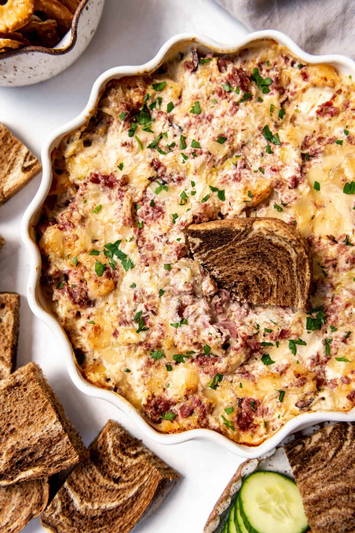Homemade reuben dip with a piece of marble rye bread in it.