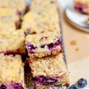 Blueberry cheesecake bars stacked on top of each other.