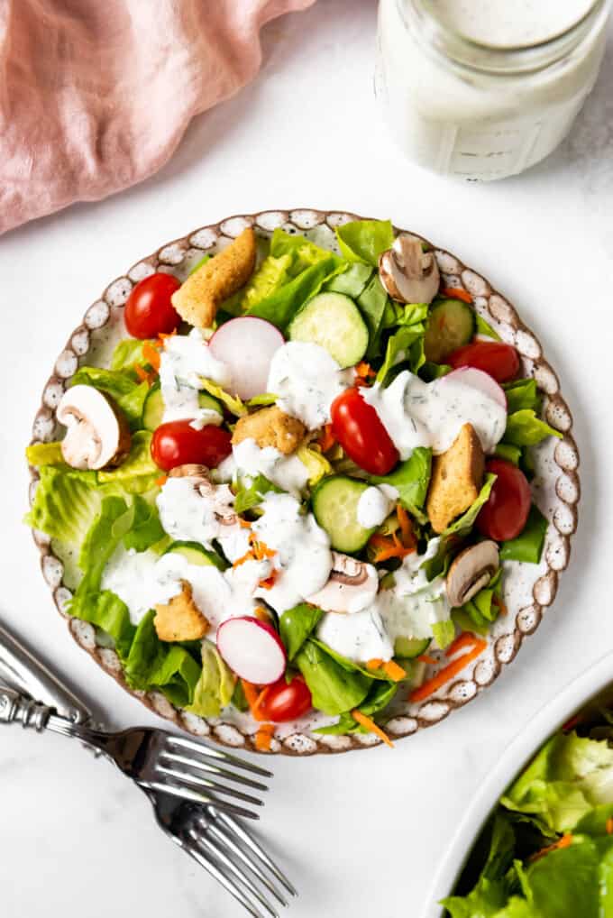 A garden salad with homemade ranch dressing on top.