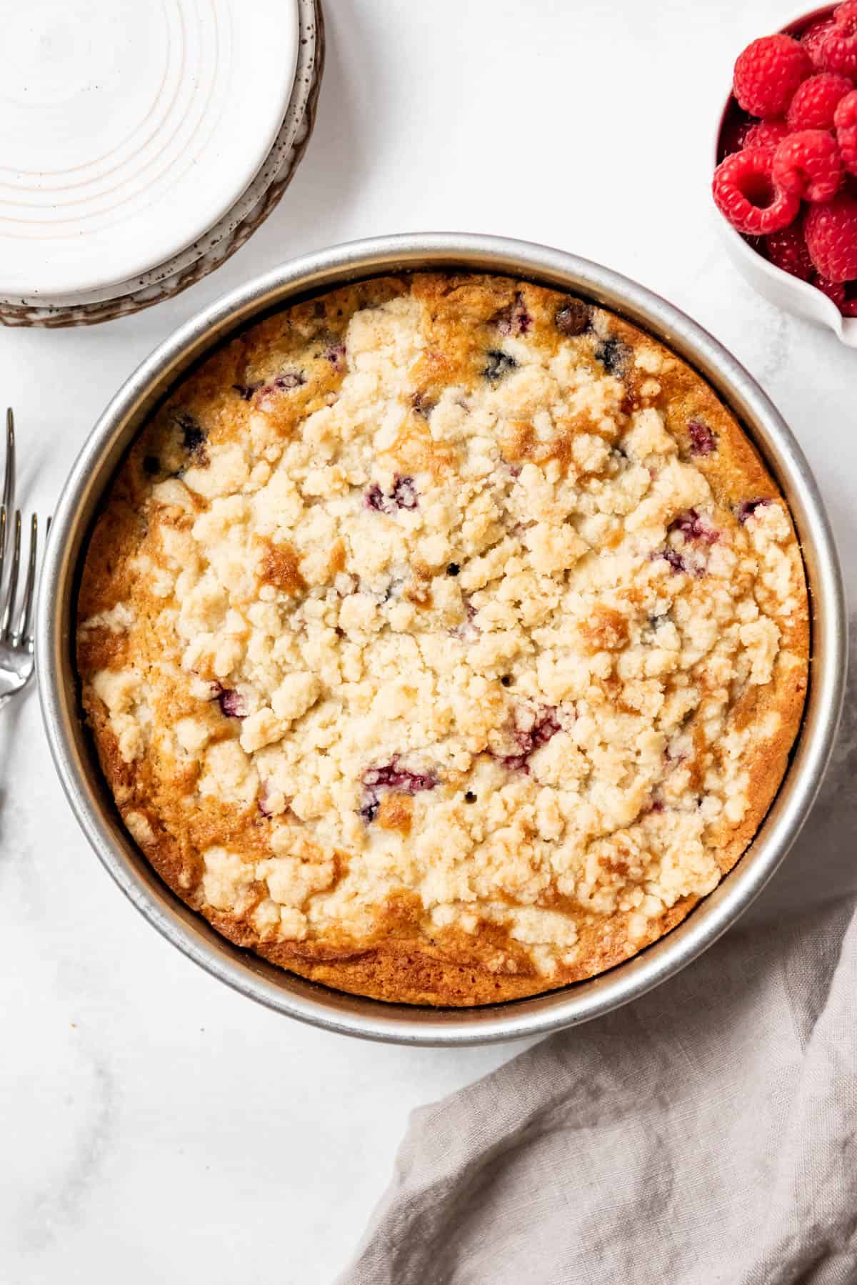 An overhead image of a mixed berry breakfast cake with crumb topping.