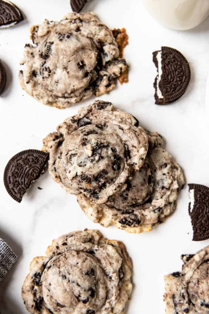An image of Oreo cheesecake cookies with broken Oreo cookies scattered around them.
