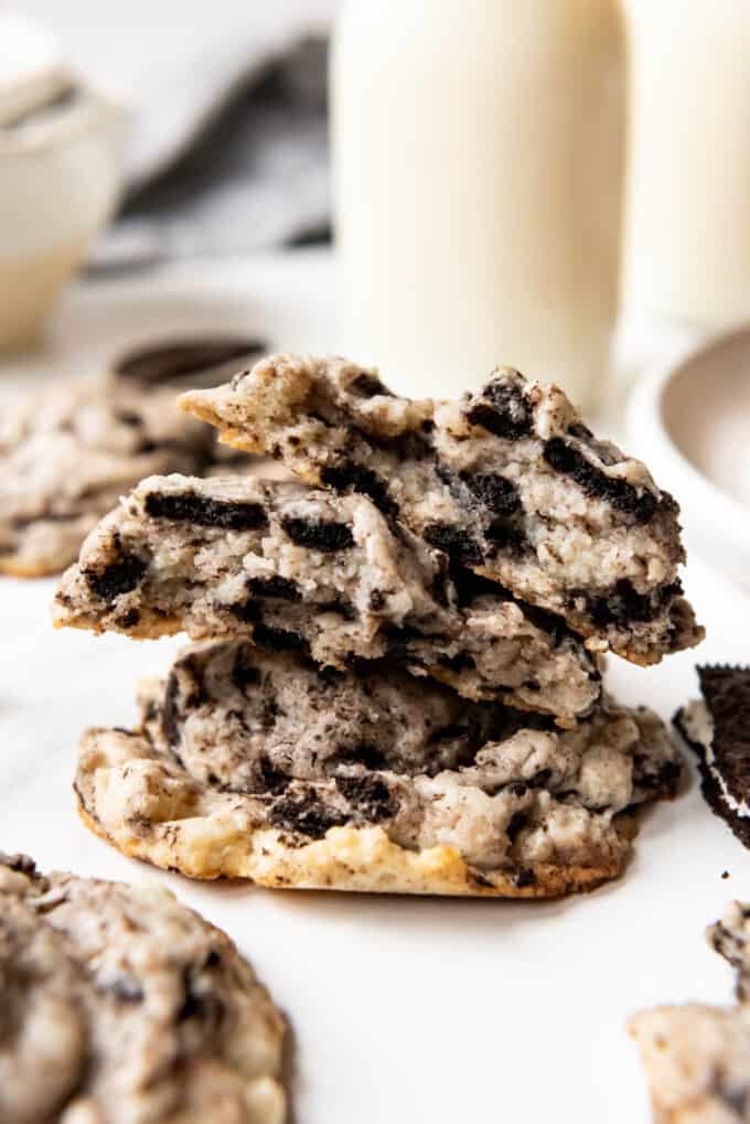 An Oreo cheesecake cookie that is broken in half and stacked on top of another cookie.