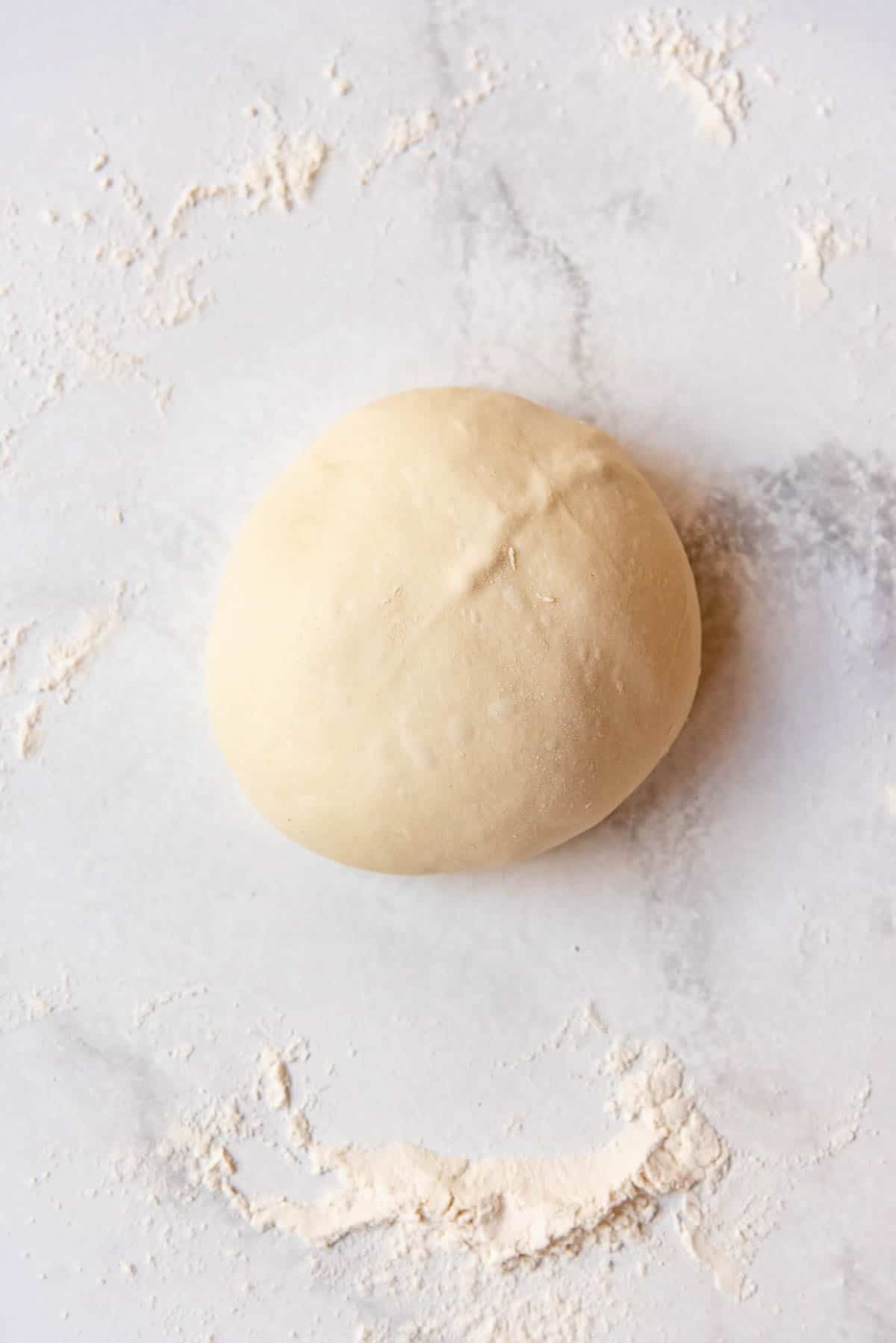 A finished, shaped ball of sourdough bread dough.