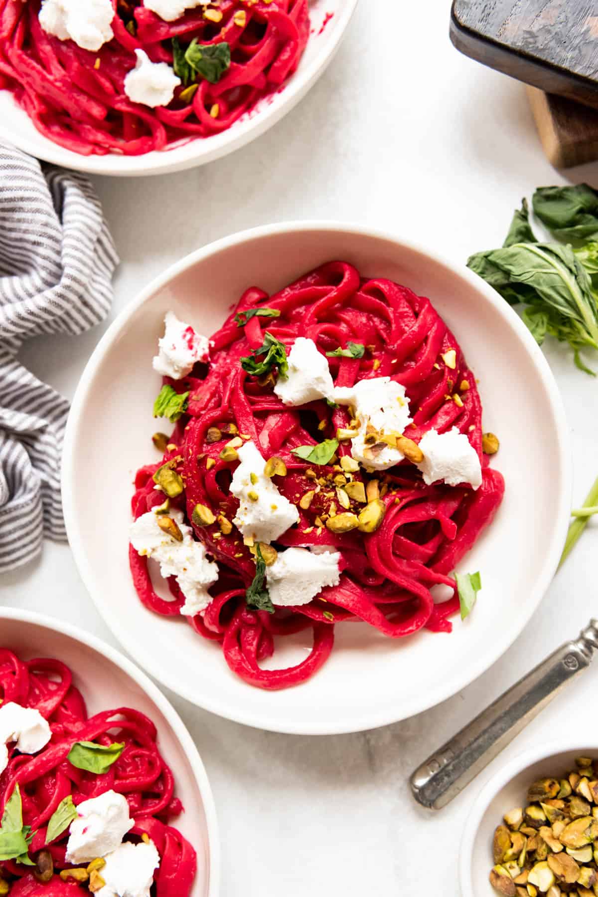 A bowl of TikTok beet pasta with goat cheese and pistachios.