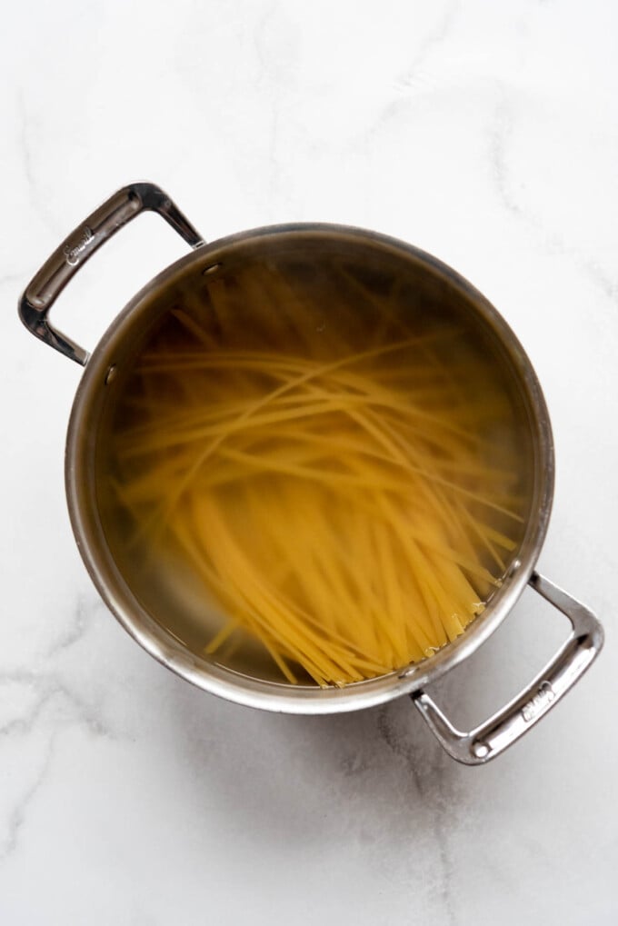 Cooking fettucine pasta in salted water in a large pot.