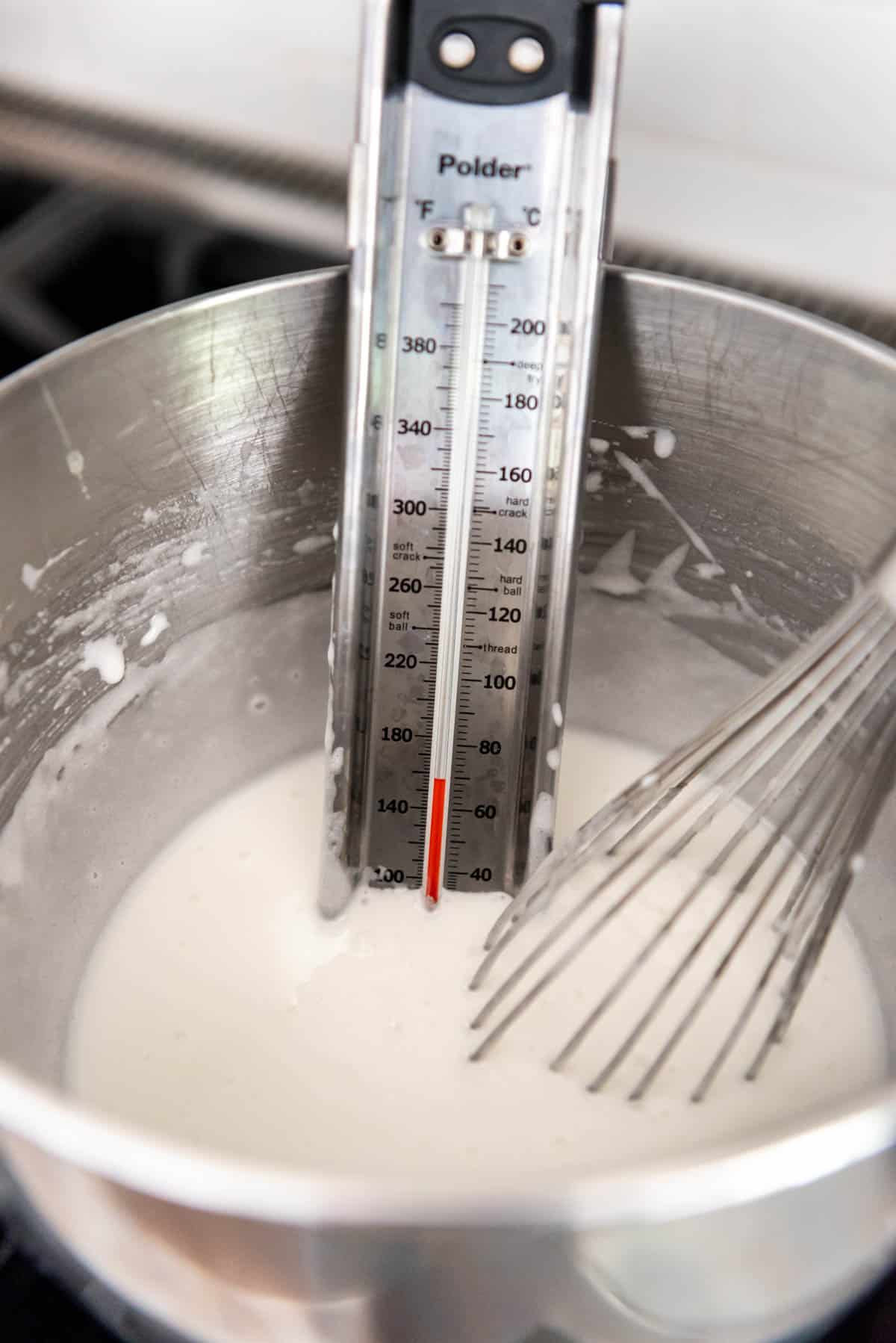 Cooking egg whites and sugar to 160°F in a bain marie.