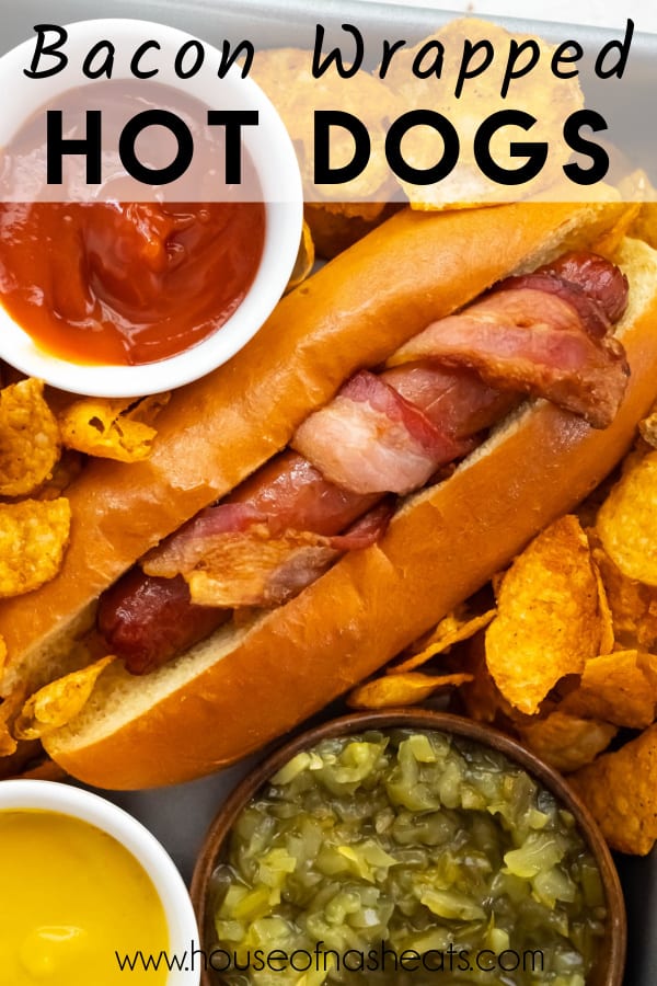 A bacon wrapped hot dog in a bun with ketchup, mustard, and relish nearby in small bowls with text overlay.
