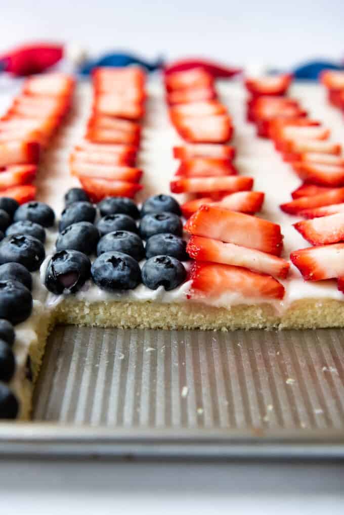 A side view of a patriotic sheet cake with fresh fruit on top.