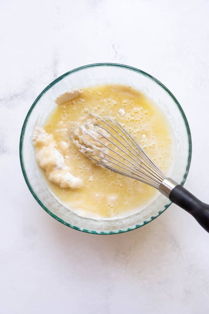 Whisking melted butter and water into dry ingredients for a white texas sheet cake.
