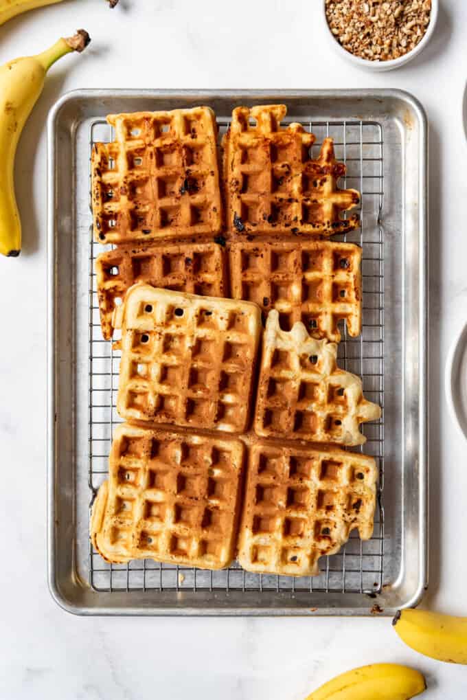 Freshly cooked waffles on a wire rack. 