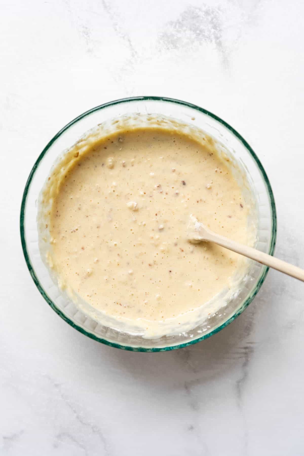 Unfinished pecan waffle batter in a mixing bowl.