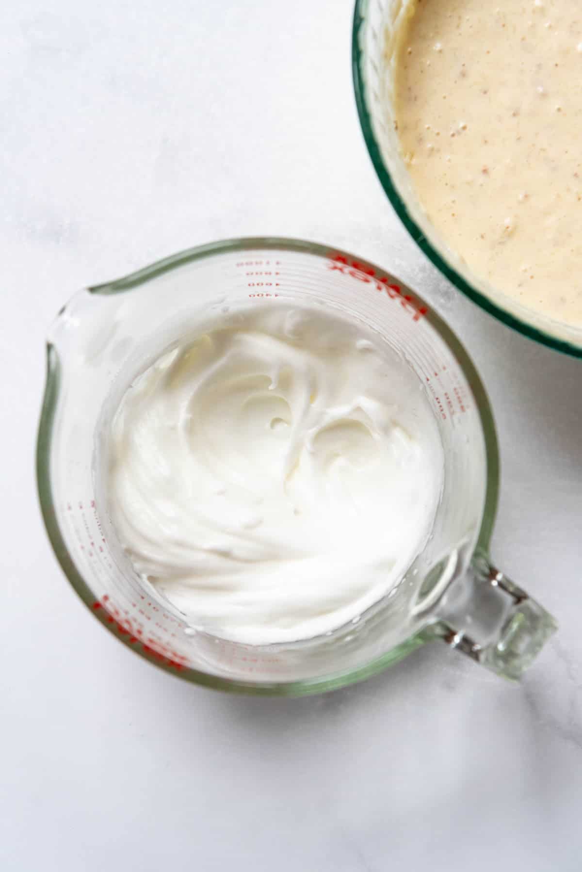 Egg whites beaten to stiff peaks in a glass mixing bowl.