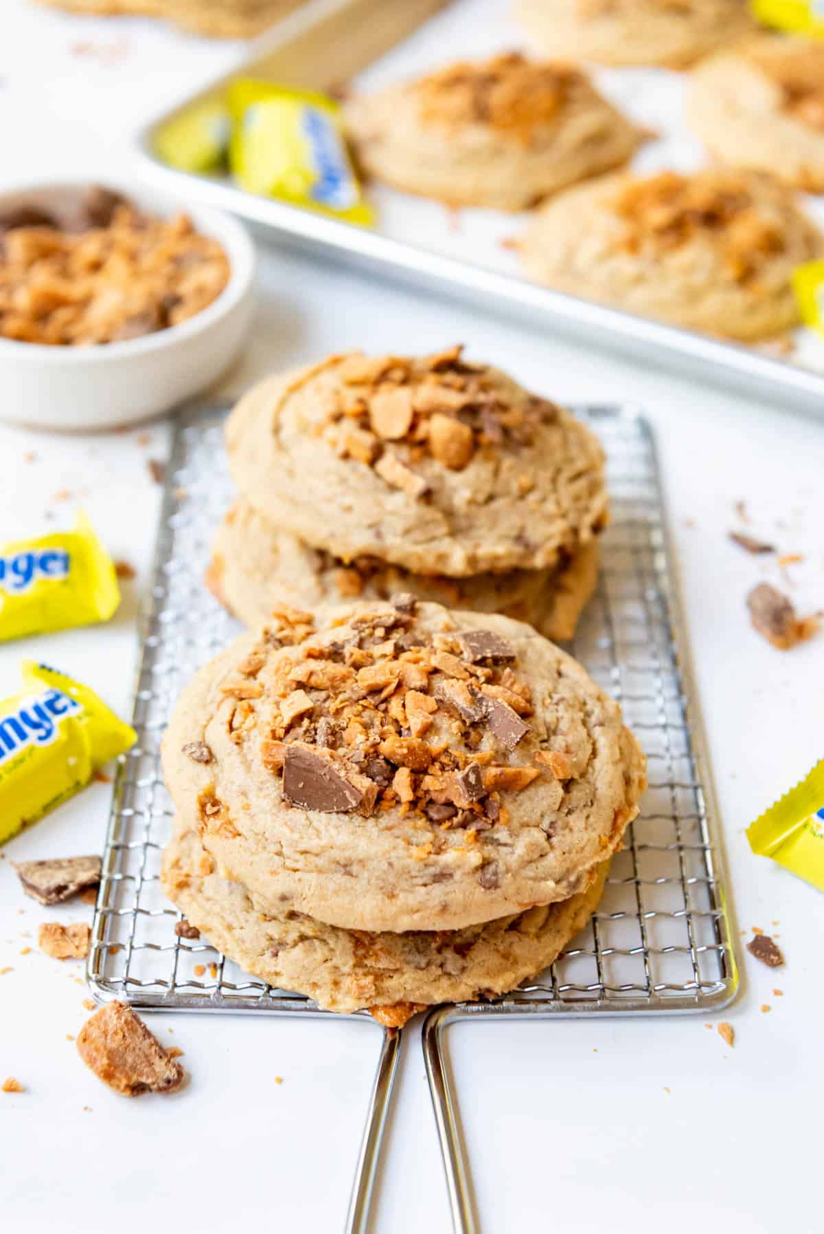 Stacked butterfingers cookies on a wire cooling rack.