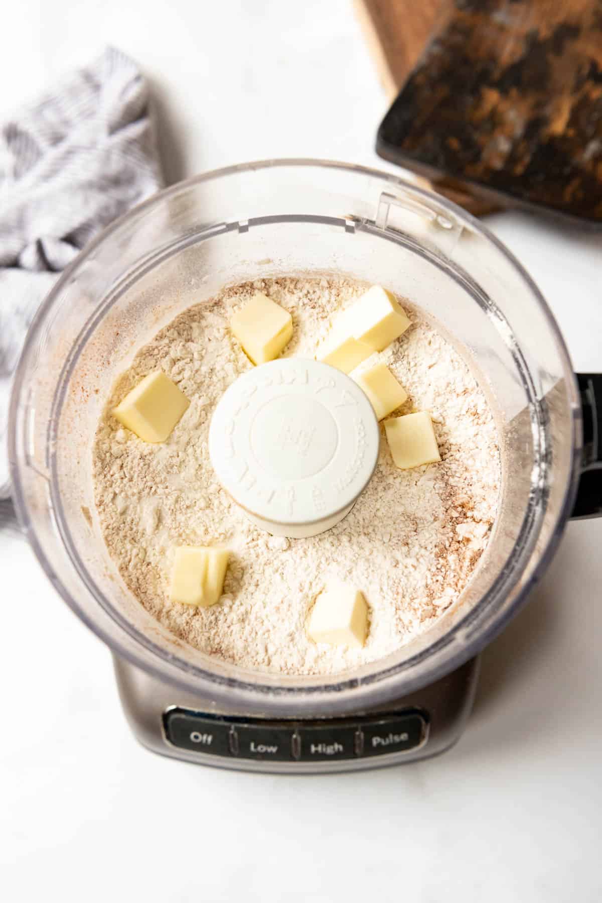 Combining butter and dry ingredients in a food processor to make cannoli dough.