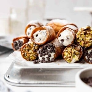 Stacked homemade cannoli with pistachios and mini chocolate chips.