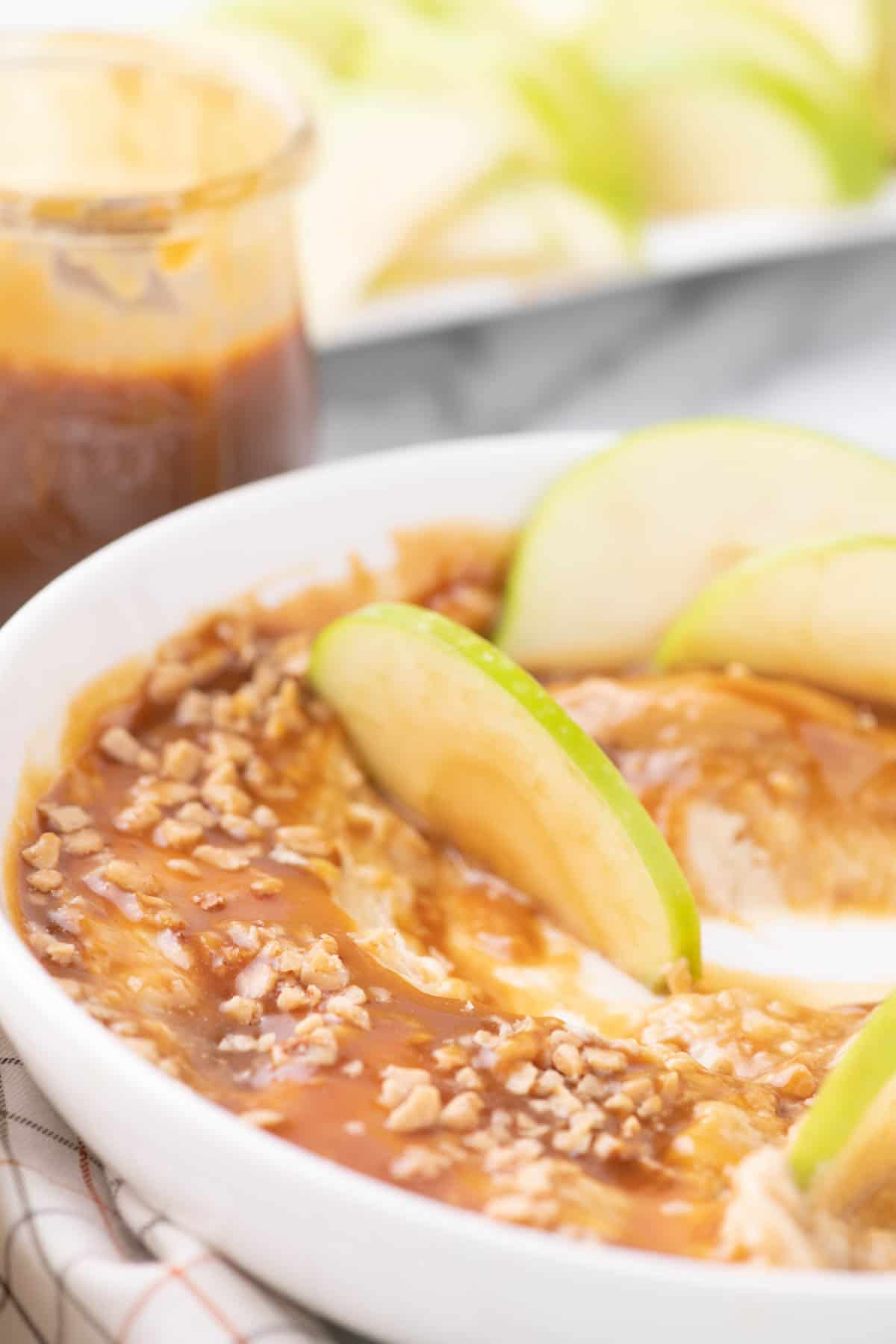 Close up of caramel apple dip ina. white serving dish.