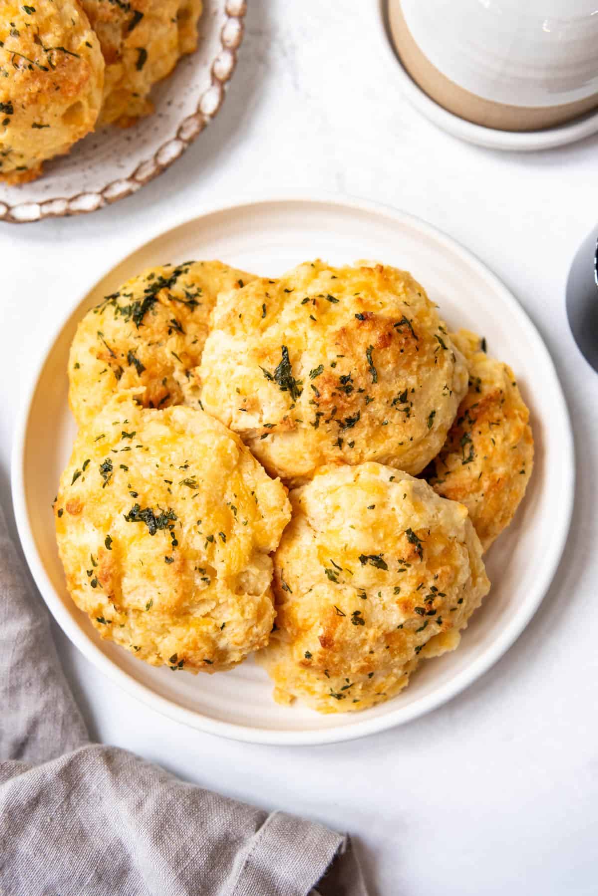 An overhead image of homemade cheddar bay biscuits on a plate.