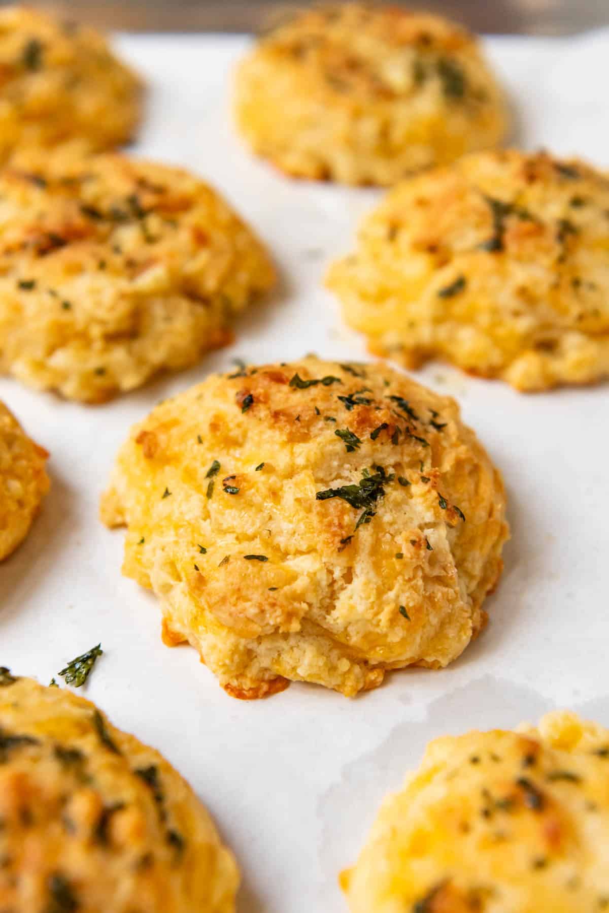 A close image of cheddar bay biscuits that have been brushed with herb garlic butter.