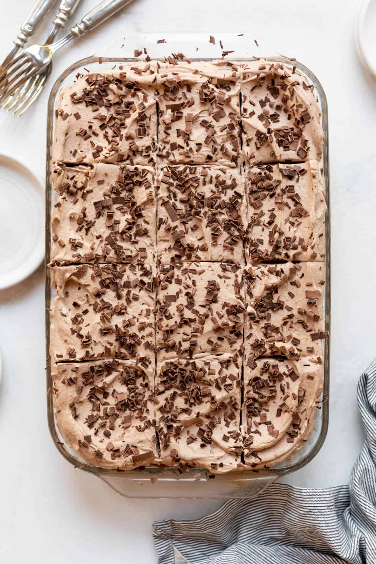An overhead image of chocolate tres leches cake with shaved chocolate sprinkled on top.