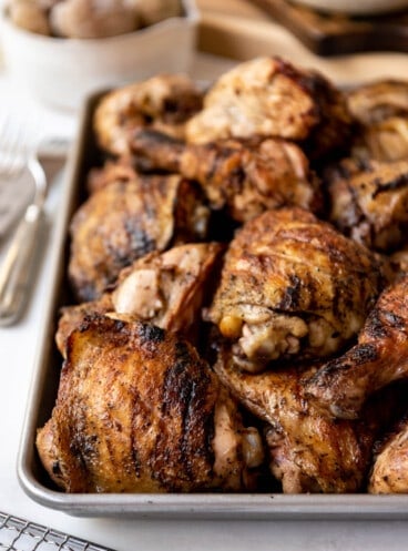 Grilled fireman's chicken pieces on a baking sheet.