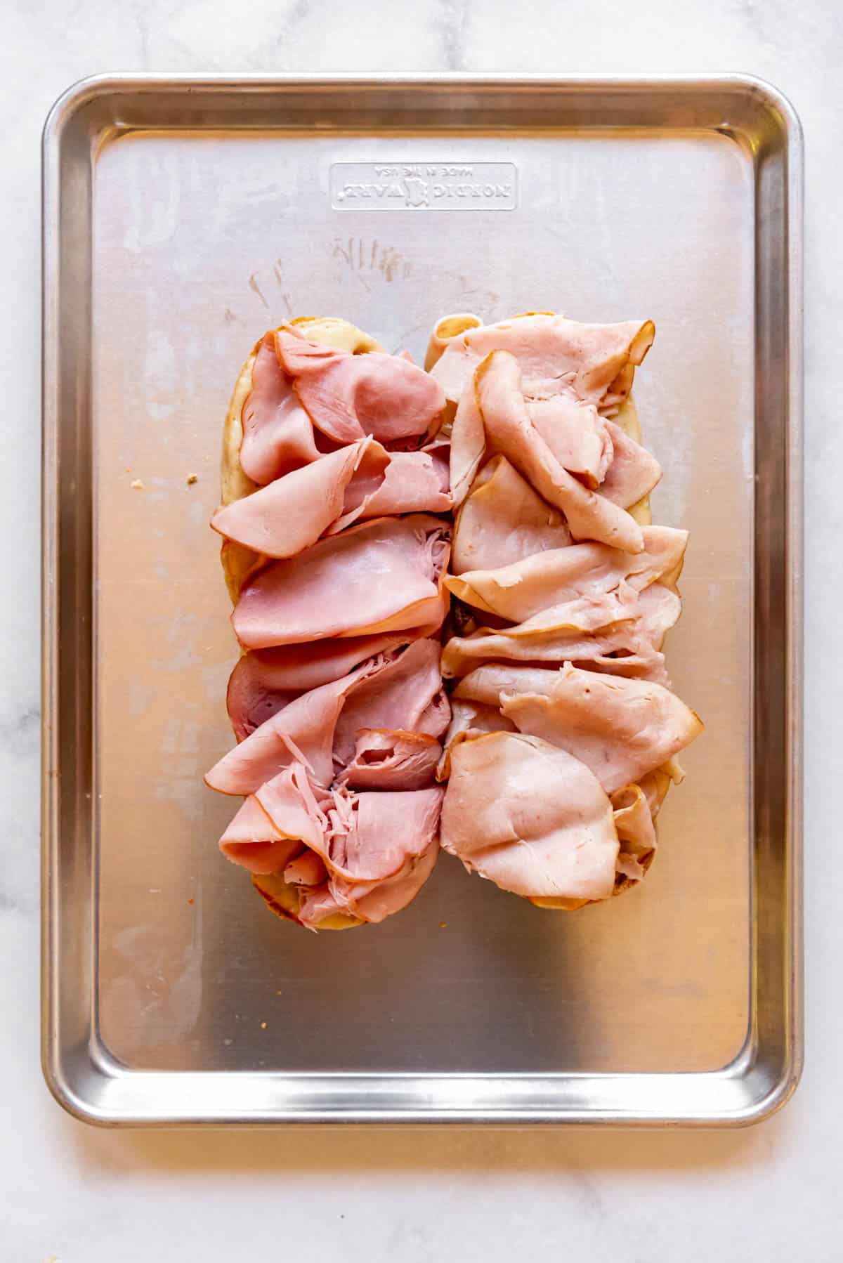 Layered thinly sliced turkey and ham on a grinder roll.