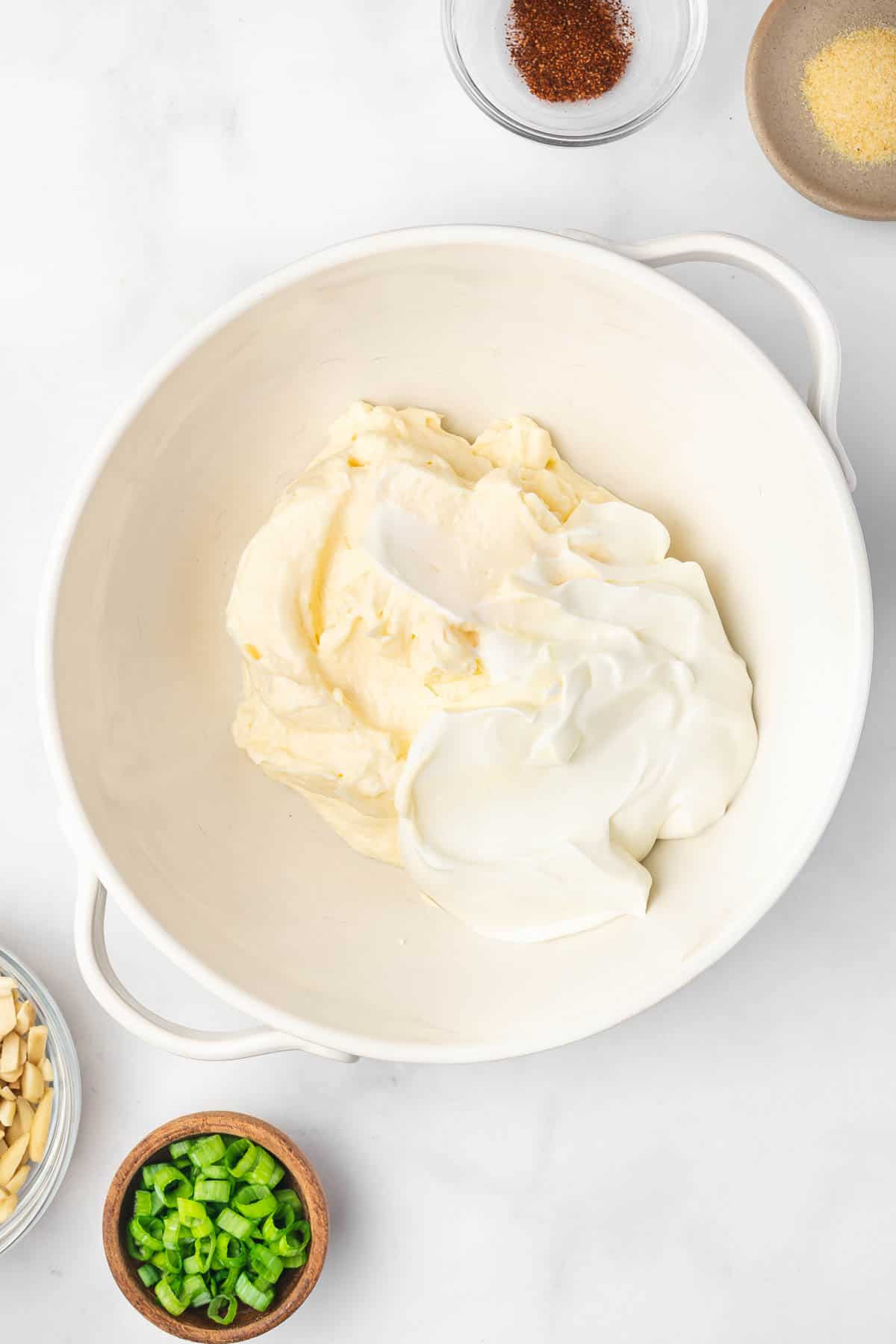 Top view of white bowl with mayonnaise and sour cream in it.