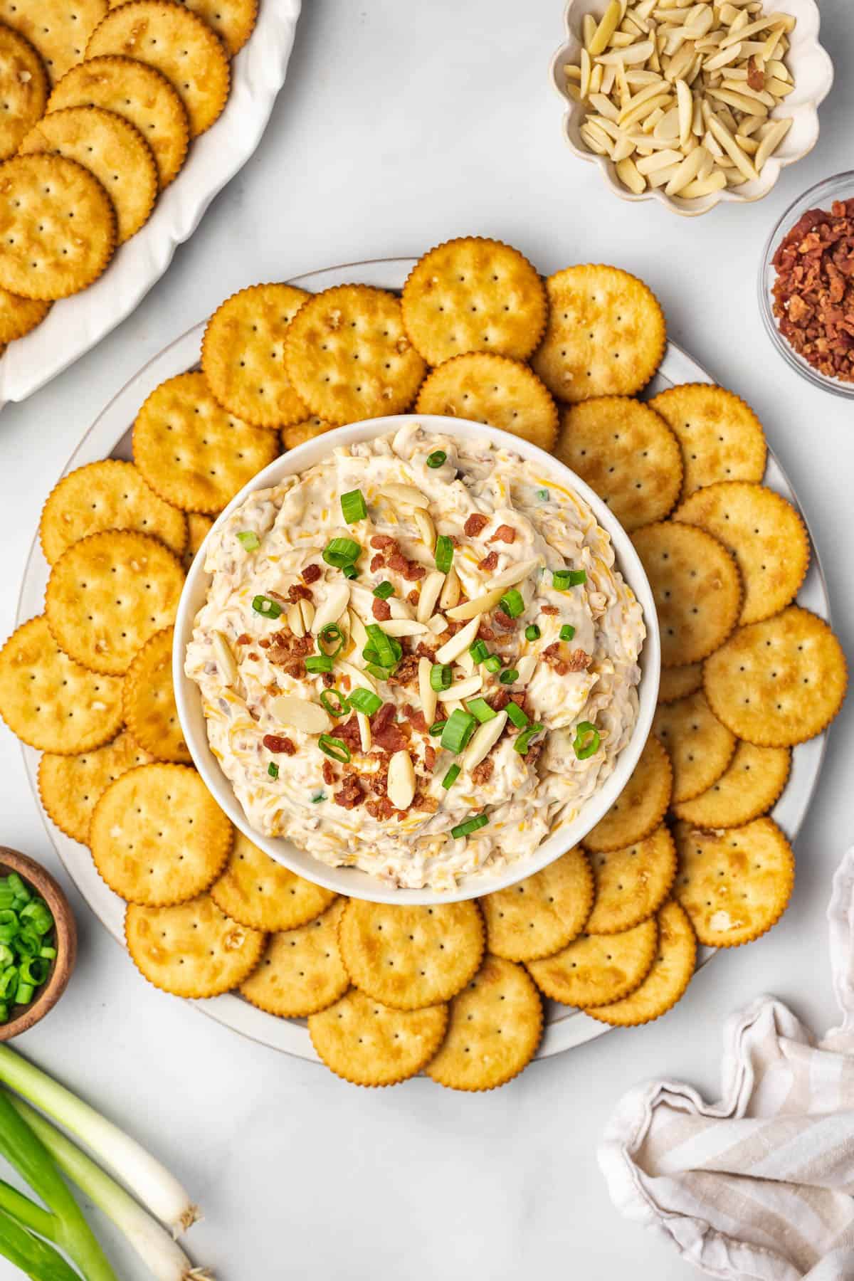 Million dollar dip in a bowl surrounded by Ritz crackers for serving.