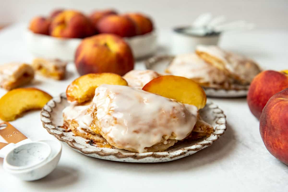 Glazed peach hand pies on a plate.