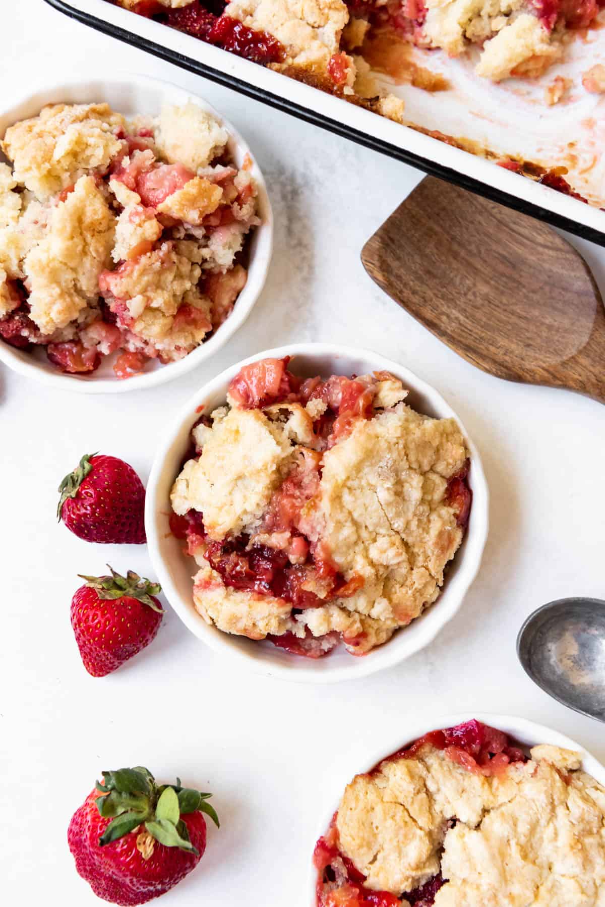 An overhead image of bowls of strawberry rhubarb cobbler.