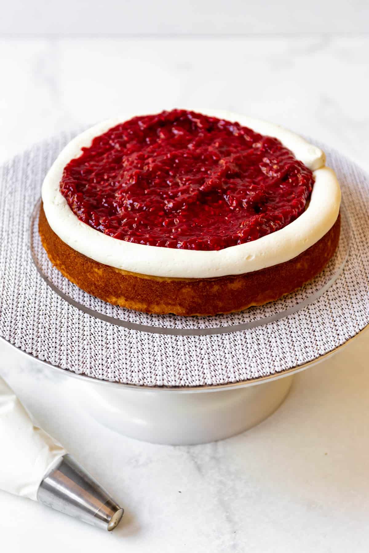 Adding raspberry cake filling to a white chocolate cake.