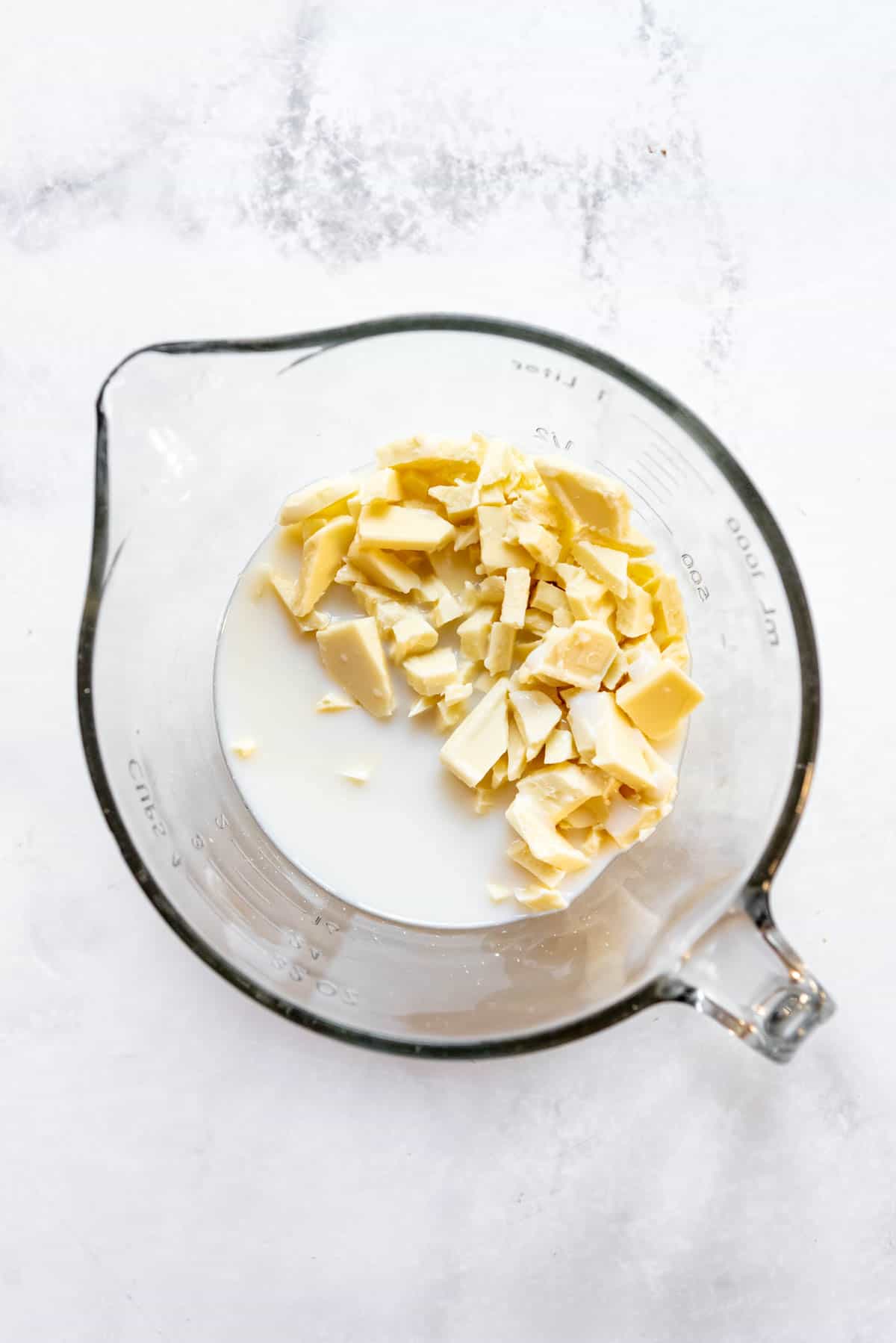 Chopped white chocolate and milk in a large bowl.