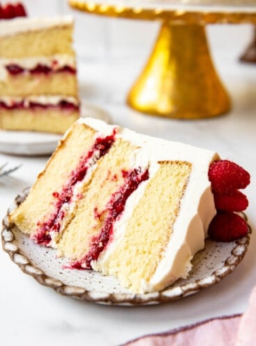 A slice of white chocolate raspberry cake on a plate.