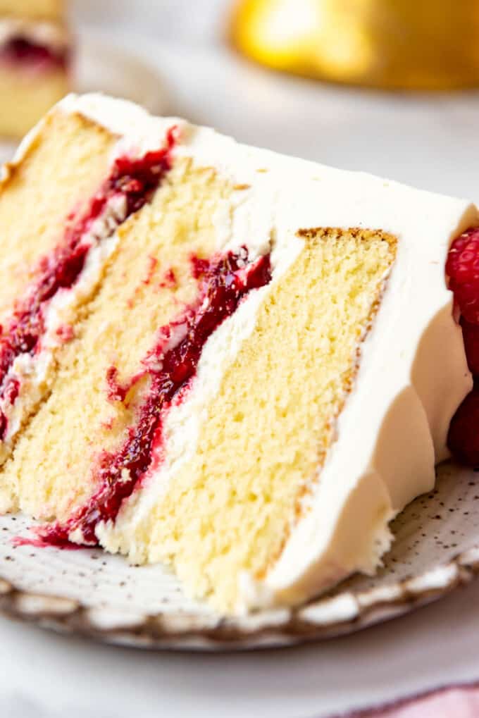 A close image of moist white chocolate cake with raspberry cake filling.