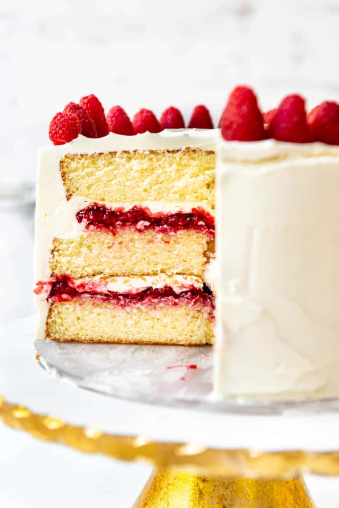 A close image of a cross section of a white chocolate raspberry cake.