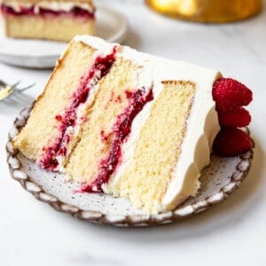 A slice of white chocolate raspberry cake on a plate.