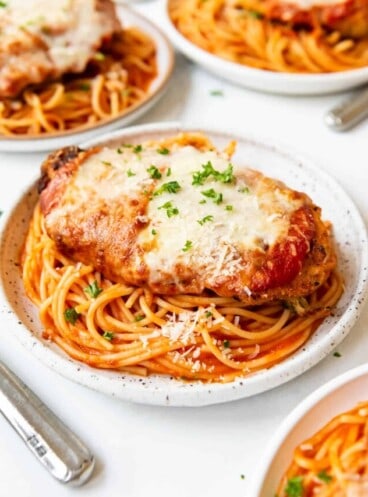 Plates of chicken parmesan with spaghetti.