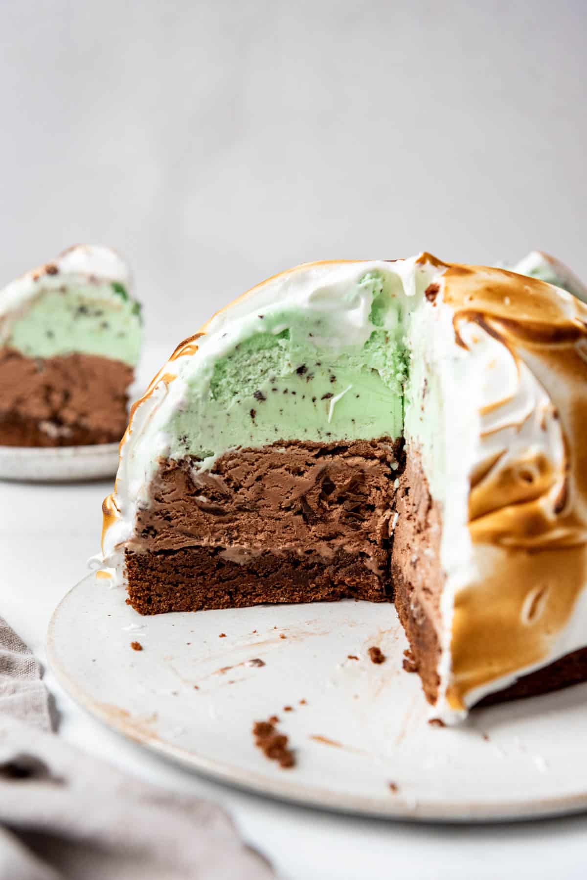A baked Alaska with layers of brownie, chocolate and mint chip ice creams.