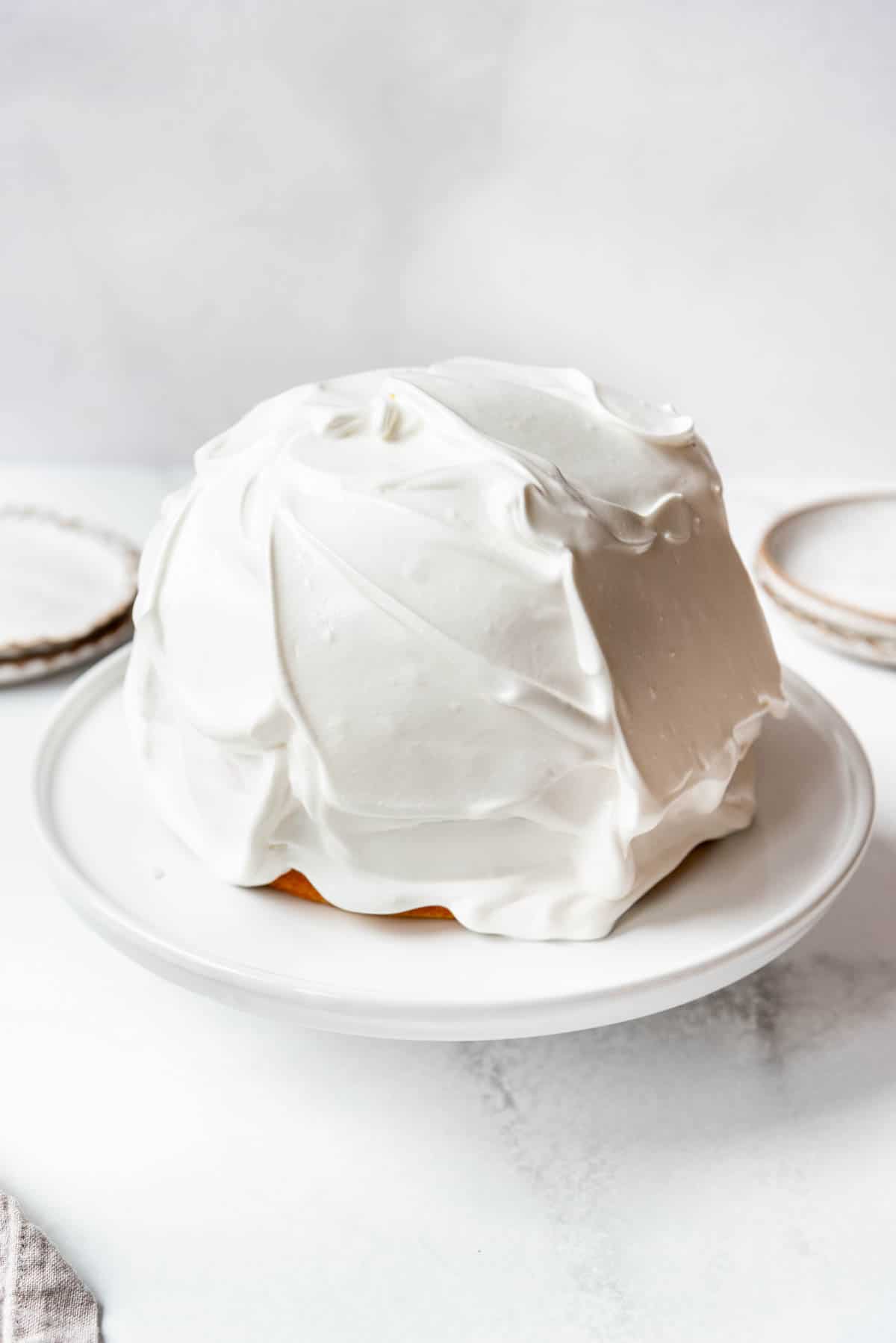 A baked Alaska covered in meringue before being toasted.