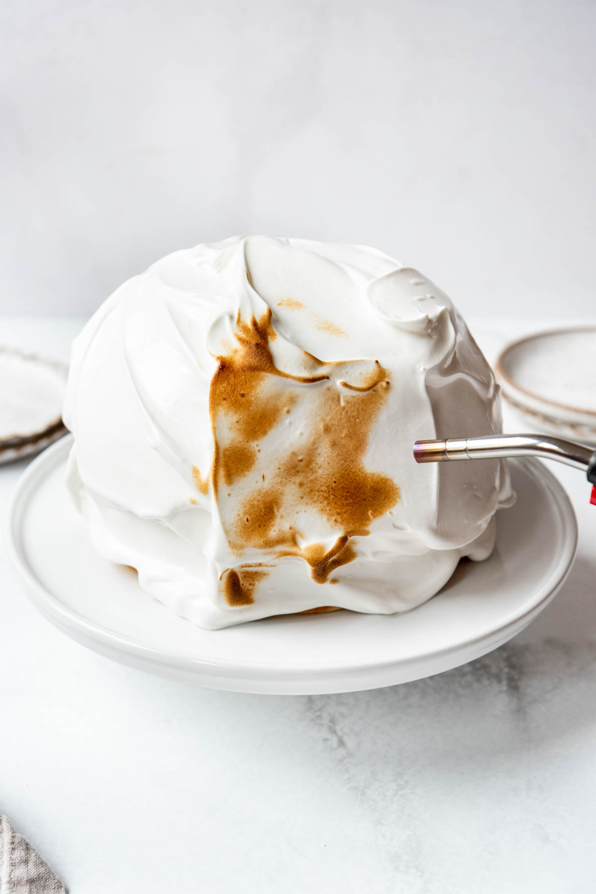 Toasting meringue on a baked Alaska with a kitchen torch.